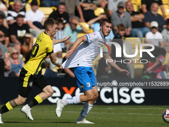 Harrogate Town's Matty Daly holds the shirt of Barrow's Dean Campbell during the Sky Bet League 2 match between Harrogate Town and Barrow at...