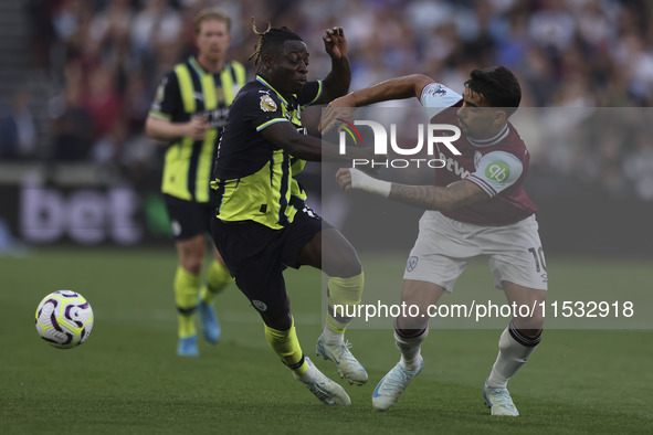 Jeremy Doku of Manchester City battles for possession with Lucas Paqueta of West Ham United during the Premier League match between West Ham...