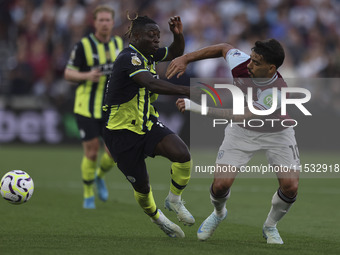 Jeremy Doku of Manchester City battles for possession with Lucas Paqueta of West Ham United during the Premier League match between West Ham...