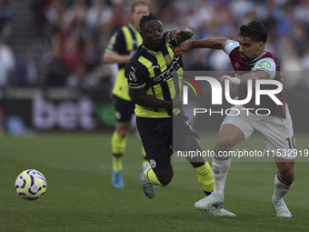 Jeremy Doku of Manchester City battles for possession with Lucas Paqueta of West Ham United during the Premier League match between West Ham...