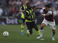 Jeremy Doku of Manchester City battles for possession with Lucas Paqueta of West Ham United during the Premier League match between West Ham...