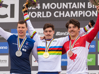 Loris Vergier of France, Finn Iles of Canada, and Benoit Coulanges of France stand on the podium at the UCI Mountain Bike World Championship...