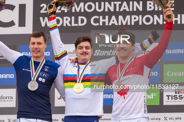 Loris Vergier of France, Finn Iles of Canada, and Benoit Coulanges of France stand on the podium at the UCI Mountain Bike World Championship...