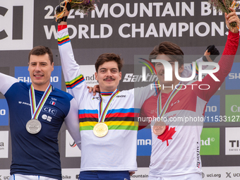 Loris Vergier of France, Finn Iles of Canada, and Benoit Coulanges of France stand on the podium at the UCI Mountain Bike World Championship...