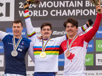 Loris Vergier of France, Finn Iles of Canada, and Benoit Coulanges of France stand on the podium at the UCI Mountain Bike World Championship...