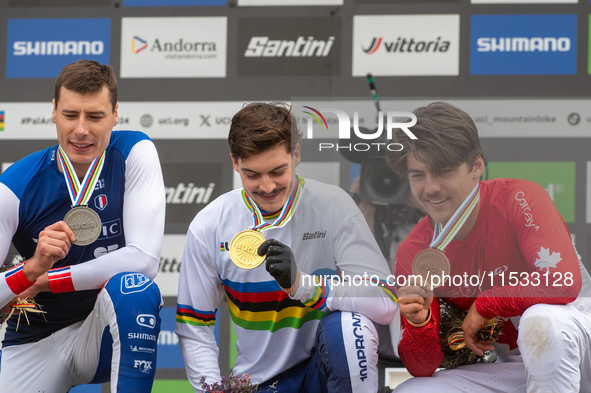 Loris Vergier of France, Finn Iles of Canada, and Benoit Coulanges of France stand on the podium at the UCI Mountain Bike World Championship...