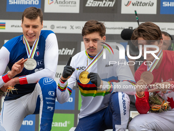 Loris Vergier of France, Finn Iles of Canada, and Benoit Coulanges of France stand on the podium at the UCI Mountain Bike World Championship...