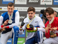 Loris Vergier of France, Finn Iles of Canada, and Benoit Coulanges of France stand on the podium at the UCI Mountain Bike World Championship...