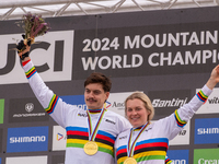 Loris Vergier of France and Valentina Holl of Austria stand on the podium at the UCI Mountain Bike World Championships Men Downhill in Pal A...