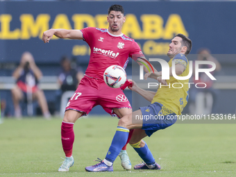 Waldo Rubio of CD Tenerife competes for the ball with Joseba Zaldua of Cadiz CF during the Liga Hypermotion match between Cadiz CF and CD Te...