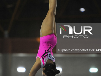 A gymnast from West Sumatra, Yulia Dian Retno, competes in the Women's Team Artistic Gymnastics Parallel Bars event of the XXI/2024 National...