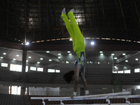 Gymnast from South Sulawesi, Rezha Saputra, competes in the Artistic Gymnastics competition on parallel bars in the men's group category at...