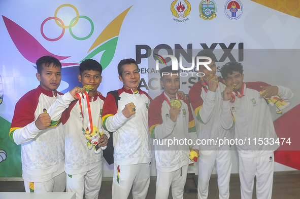 The Riau Contingent Men's Gymnastics athlete team poses together while receiving the gold award on the first day of the Artistic Gymnastics...