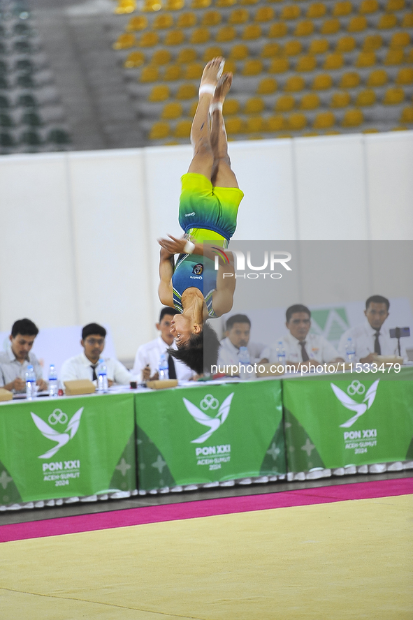 A gymnast from South Sulawesi, Rezha Saputra, spins in the air during the first round match of the men's group per floor apparatus of the XX...