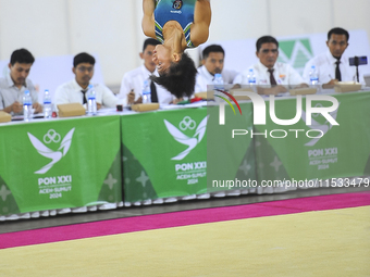 A gymnast from South Sulawesi, Rezha Saputra, spins in the air during the first round match of the men's group per floor apparatus of the XX...