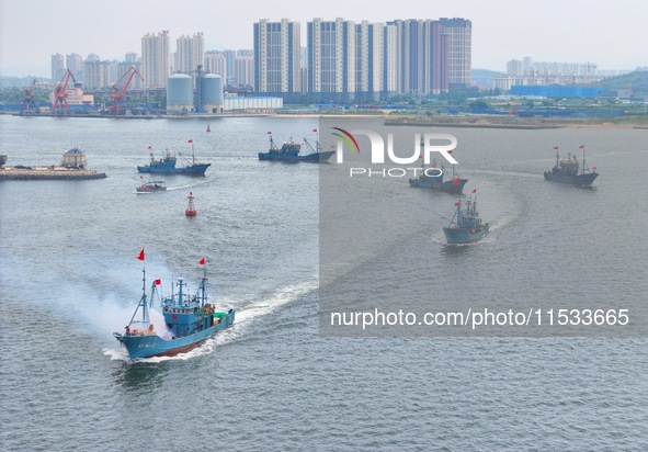 Fishing boats go out to sea from the central fishing port of Yangma Island in Yantai, China, on September 1, 2024. 