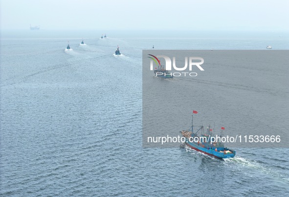 Fishing boats go out to sea from the central fishing port of Yangma Island in Yantai, China, on September 1, 2024. 