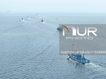 Fishing boats go out to sea from the central fishing port of Yangma Island in Yantai, China, on September 1, 2024. (