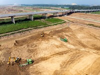 Excavators and trucks work in the river channel at the construction site of the second phase of the Huaihe River Waterway into the sea in Hu...