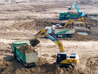 Excavators and trucks work in the river channel at the construction site of the second phase of the Huaihe River Waterway into the sea in Hu...