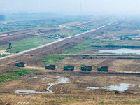 Excavators and trucks work in the river channel at the construction site of the second phase of the Huaihe River Waterway into the sea in Hu...