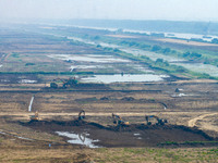 Excavators and trucks work in the river channel at the construction site of the second phase of the Huaihe River Waterway into the sea in Hu...