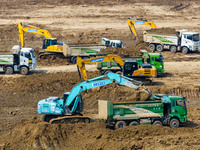 Excavators and trucks work in the river channel at the construction site of the second phase of the Huaihe River Waterway into the sea in Hu...