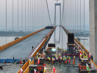 Workers spread asphalt on the deck of the main bridge of the Longtan Yangtze River Bridge in Yangzhou, China, on September 1, 2024. (