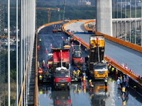 Workers spread asphalt on the deck of the main bridge of the Longtan Yangtze River Bridge in Yangzhou, China, on September 1, 2024. (