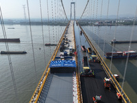 Workers spread asphalt on the deck of the main bridge of the Longtan Yangtze River Bridge in Yangzhou, China, on September 1, 2024. (