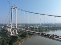 Workers spread asphalt on the deck of the main bridge of the Longtan Yangtze River Bridge in Yangzhou, China, on September 1, 2024. (