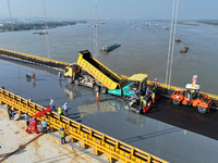 Workers spread asphalt on the deck of the main bridge of the Longtan Yangtze River Bridge in Yangzhou, China, on September 1, 2024. (