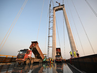 Workers spread asphalt on the deck of the main bridge of the Longtan Yangtze River Bridge in Yangzhou, China, on September 1, 2024. (