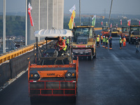 Workers spread asphalt on the deck of the main bridge of the Longtan Yangtze River Bridge in Yangzhou, China, on September 1, 2024. (