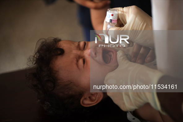 A Palestinian child receives a polio vaccination at a United Nations healthcare center in Deir Al-Balah in the central Gaza Strip, on Septem...