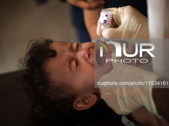 A Palestinian child receives a polio vaccination at a United Nations healthcare center in Deir Al-Balah in the central Gaza Strip, on Septem...