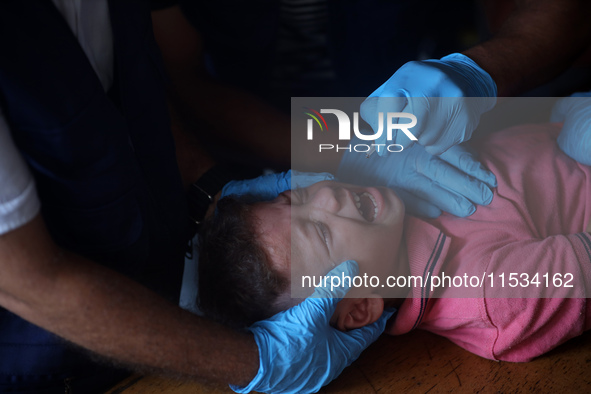 A Palestinian child receives a polio vaccination at a United Nations healthcare center in Deir Al-Balah in the central Gaza Strip, on Septem...