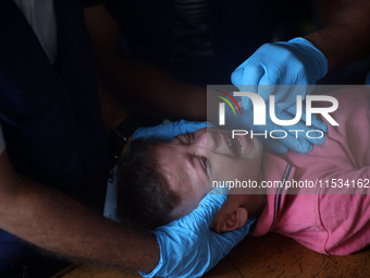 A Palestinian child receives a polio vaccination at a United Nations healthcare center in Deir Al-Balah in the central Gaza Strip, on Septem...