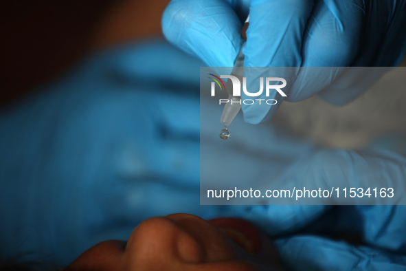 A Palestinian child receives a polio vaccination at a United Nations healthcare center in Deir Al-Balah in the central Gaza Strip, on Septem...