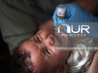 A Palestinian child receives a polio vaccination at a United Nations healthcare center in Deir Al-Balah in the central Gaza Strip, on Septem...