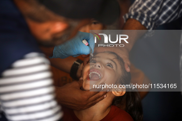 A Palestinian child receives a polio vaccination at a United Nations healthcare center in Deir Al-Balah in the central Gaza Strip, on Septem...