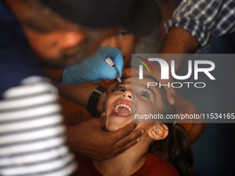 A Palestinian child receives a polio vaccination at a United Nations healthcare center in Deir Al-Balah in the central Gaza Strip, on Septem...