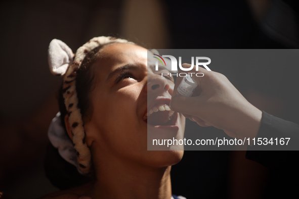 A Palestinian child receives a polio vaccination at a United Nations healthcare center in Deir Al-Balah in the central Gaza Strip, on Septem...