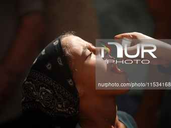 A Palestinian child receives a polio vaccination at a United Nations healthcare center in Deir Al-Balah in the central Gaza Strip, on Septem...