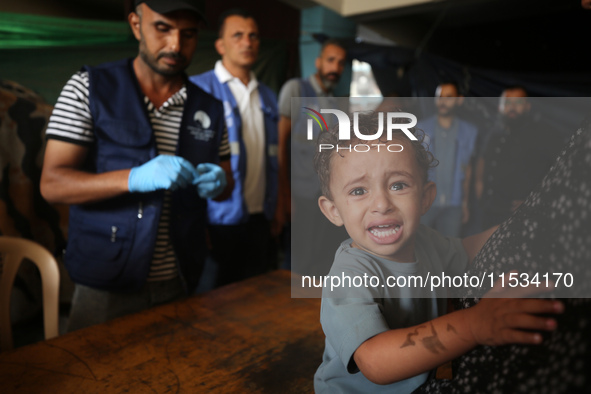 A Palestinian child receives a polio vaccination at a United Nations healthcare center in Deir Al-Balah in the central Gaza Strip, on Septem...