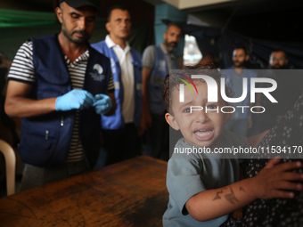 A Palestinian child receives a polio vaccination at a United Nations healthcare center in Deir Al-Balah in the central Gaza Strip, on Septem...