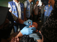 A Palestinian child receives a polio vaccination at a United Nations healthcare center in Deir Al-Balah in the central Gaza Strip, on Septem...