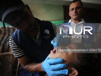 A Palestinian child receives a polio vaccination at a United Nations healthcare center in Deir Al-Balah in the central Gaza Strip, on Septem...