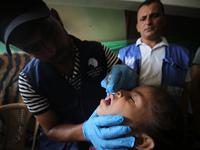 A Palestinian child receives a polio vaccination at a United Nations healthcare center in Deir Al-Balah in the central Gaza Strip, on Septem...