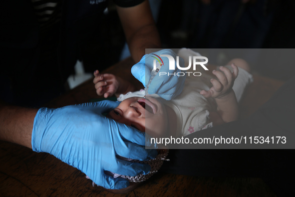 A Palestinian child receives a polio vaccination at a United Nations healthcare center in Deir Al-Balah in the central Gaza Strip, on Septem...